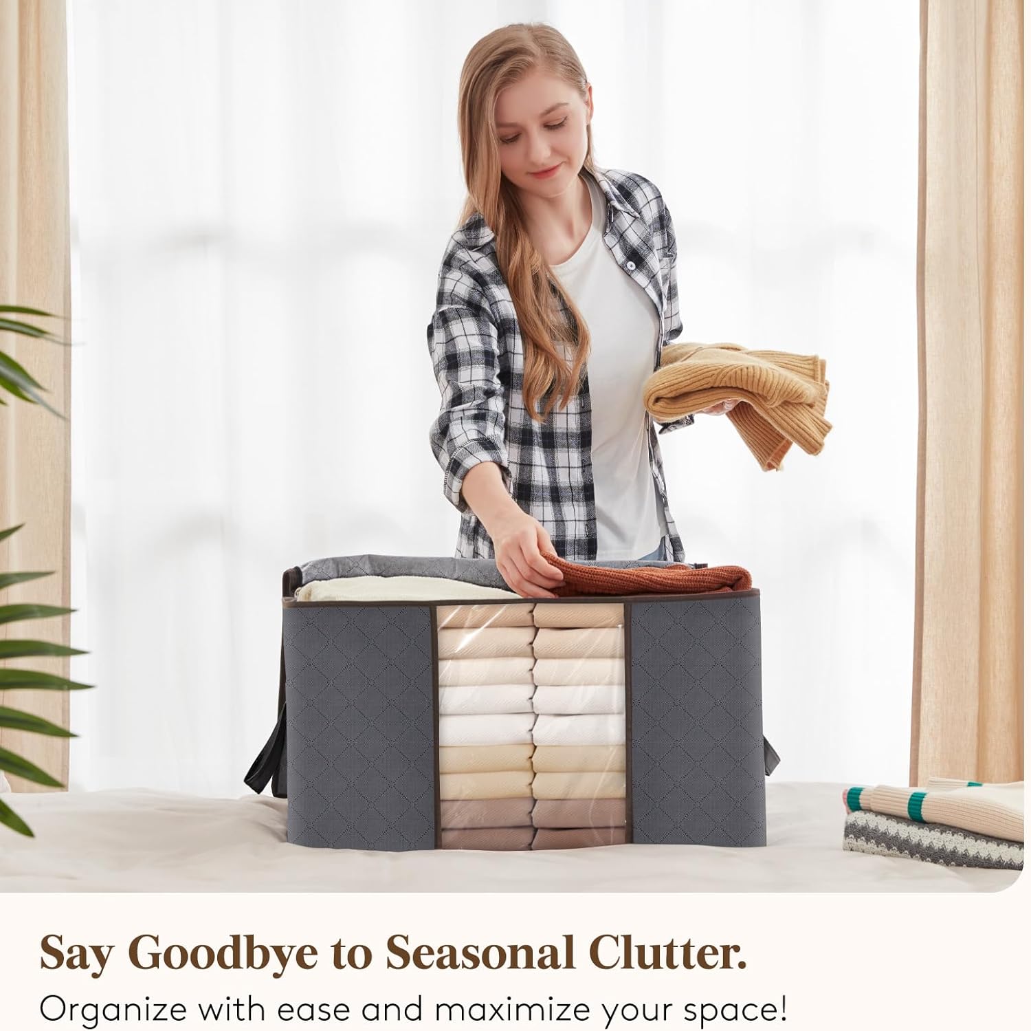 Woman packing folded knitwear into a Boxora bag on a bed by a bright window
